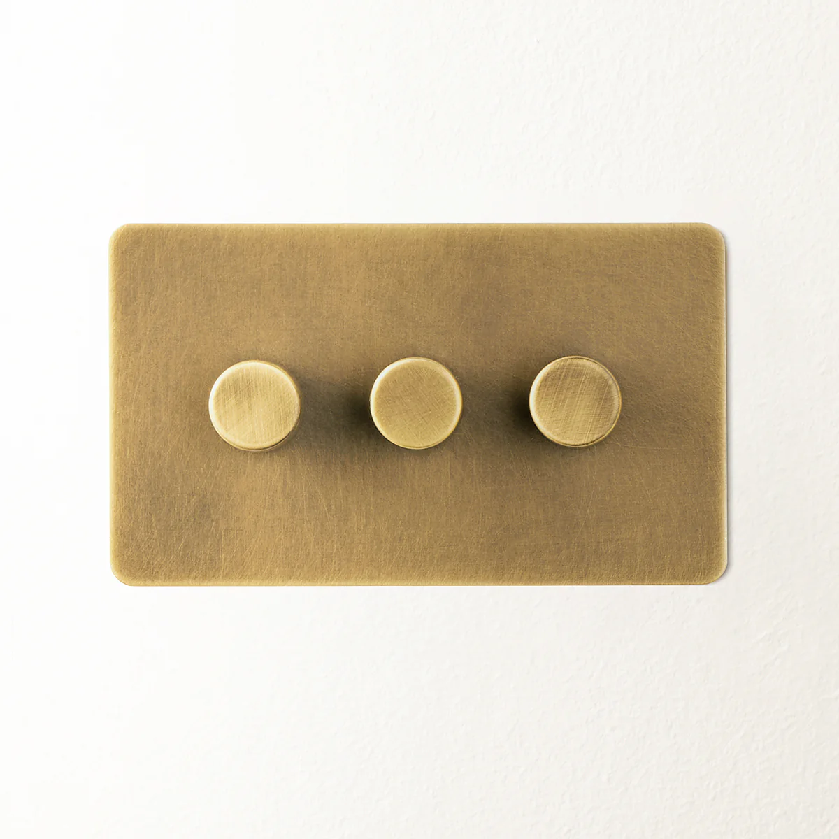 Lucian three gang dimmer switch in aged brass